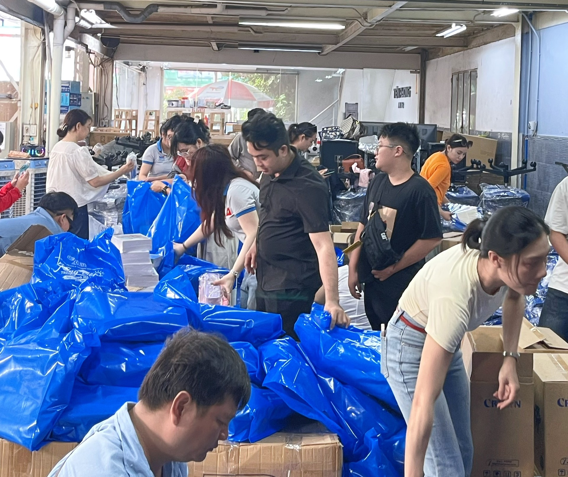Tất cả mọi người trong chương trình chung tay hỗ trợ gói quà trao tặng đến các em nhỏ tại Lào